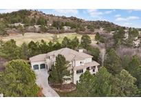 Expansive estate on a lush green golf course with mature trees and beautiful landscaping at 937 Aztec Dr, Castle Rock, CO 80108