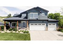 Charming two-story home with a well-manicured lawn and a two-car garage at 6123 Dunraven Rd, Golden, CO 80403