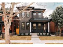 Beautifully renovated two-story home with brick facade, covered porch, and manicured front yard at 2751 Curtis St, Denver, CO 80205