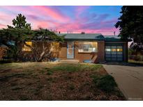 Charming brick home featuring a well-manicured front lawn and an attached garage at twilight at 476 Zion St, Aurora, CO 80011