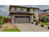 Two-story home featuring an attached two-car garage and a well maintained lawn at 10906 Touchstone Loop, Parker, CO 80134