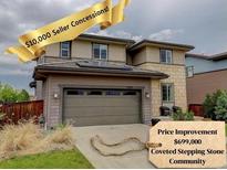 Charming two-story home featuring a two car garage, stone accents, and mature landscaping at 10906 Touchstone Loop, Parker, CO 80134