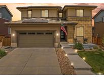 Charming two-story home featuring a two-car garage, solar panels, and well-lit walkway to the front door at 10906 Touchstone Loop, Parker, CO 80134