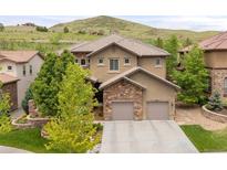 Gorgeous home boasts a two-car garage, beautiful landscaping, and a hill view, offering a blend of luxury and nature at 14841 W Warren Ave, Lakewood, CO 80228