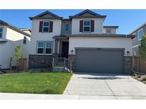 Charming two-story home featuring a manicured lawn and neutral-toned exterior, complemented by a gray two-car garage at 16634 W 93Rd Way, Arvada, CO 80007