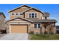 Two-story home featuring stone accents, attached two-car garage and manicured front lawn at 17555 Lake Overlook Ct, Monument, CO 80132