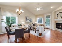 Inviting living room boasts hardwood floors, vaulted ceilings, fireplace, and an open dining area at 8255 E 150Th Pl, Thornton, CO 80602