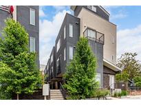 Contemporary townhome with gray stucco, modern windows, and mature trees in a vibrant urban setting at 4922 Lowell Blvd # 2, Denver, CO 80221
