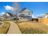 Charming two-story home featuring a fenced backyard and a well-maintained lawn on a beautiful day at 55429 E 31St Ave, Strasburg, CO 80136