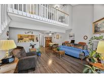 Bright living room boasts hardwood floors, fireplace and a soaring vaulted ceiling with a loft overlooking the space at 1865 S Union Blvd, Lakewood, CO 80228