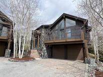 Brown two-story home with stone accents, a balcony, and a two-car garage at 19 South Rd, Breckenridge, CO 80424