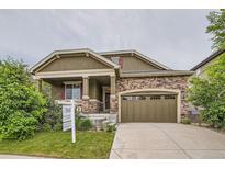 Charming two-story home with stone accents, covered porch and landscaped front yard at 13424 W 64Th Pl, Arvada, CO 80004