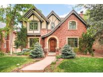 Charming brick home with Tudor-style accents, arched entry, and professionally landscaped front yard at 958 S Columbine St, Denver, CO 80209