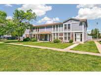 Inviting exterior view of a two-story townhome with lush lawn and beautiful landscaping at 12020 E Canal Dr, Aurora, CO 80011