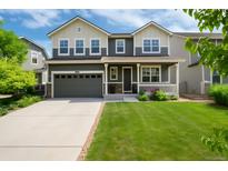 Beautiful two-story home features a well-manicured lawn, spacious driveway, and charming covered front porch at 3027 Walnut Grove St, Erie, CO 80516