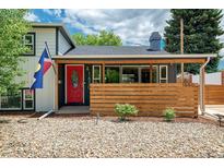 Charming home featuring a red door, wood slat accent wall, and Colorado flag at 1650 S Holly St, Denver, CO 80222