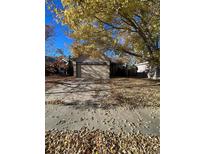 Ranch-style home with two-car garage and mature trees in the front yard at 4063 S Himalaya Way, Aurora, CO 80013