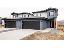 Modern townhome showcasing a black garage door, blue siding, and gray roof at 12575 W 10Th Ave, Golden, CO 80401