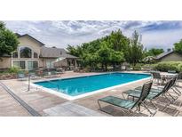 Relaxing community pool area with lounge chairs, tables, and lush landscaping at 8671 E Dry Creek Rd # 721, Englewood, CO 80112