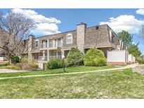 Townhome exterior with well-maintained lawn, mature trees, and private balconies on the upper levels at 1350 S Idalia St # G, Aurora, CO 80017