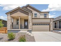 Beautiful two-story home featuring a stone and siding exterior with a two-car garage at 9264 Biscay St, Commerce City, CO 80022