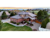 Beautiful brick home featuring professional landscaping and a tile roof at 5925 Zinnia Ct, Arvada, CO 80004