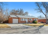 Charming red brick single story home featuring a attached garage, green front lawn, and mature trees at 6359 Brooks Dr, Arvada, CO 80004