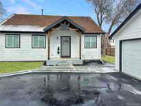Charming bungalow with a well-maintained lawn and a covered front porch at 22 S Harlan St, Lakewood, CO 80226