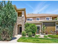 Charming townhome featuring a stone pillar, manicured lawn, and inviting outdoor seating area at 6292 Kilmer Loop # 201, Golden, CO 80403