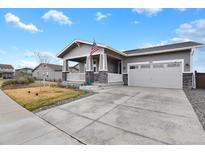 Charming single Gathering home with a well-manicured lawn, inviting porch, and a two-car garage at 1925 Peregrine Dr, Brighton, CO 80601