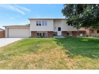 Charming two-story home with a well-maintained lawn and traditional architectural details on a sunny day at 6994 W Hinsdale Dr, Littleton, CO 80128