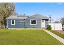 Charming home with a well-manicured lawn, modern siding, solar panels, and a welcoming walkway leading to the front door at 1498 S Perry St, Denver, CO 80219