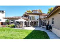 Backyard featuring a well-manicured lawn, patio, and a dining area for outdoor entertaining at 3299 S Newcombe St, Lakewood, CO 80227