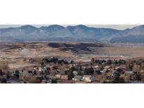 Scenic view of the community featuring golf course homes nestled against a backdrop of majestic mountains at 3299 S Newcombe St, Lakewood, CO 80227