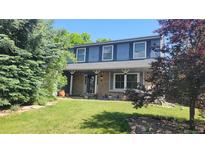 Charming blue two-story home featuring a well-maintained lawn and inviting curb appeal at 9963 W Canyon Ave, Littleton, CO 80127