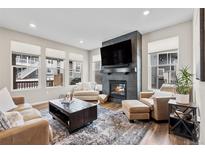 Cozy living room features a fireplace, large TV, and comfortable seating beneath lots of natural light at 138 Lullaby Ln, Castle Rock, CO 80109