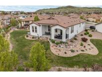 Well-maintained backyard featuring a patio, landscaped garden, and views of the surrounding community at 15156 W Baker Pl, Lakewood, CO 80228