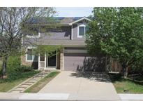 Charming two-story home with a well-manicured lawn, a stone pathway, and a two-car garage at 2517 S Genoa St, Aurora, CO 80013