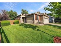 Charming single-Gathering home featuring stone accents and a well-manicured lawn at 10179 Cherryhurst Ln, Highlands Ranch, CO 80126
