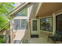 Inviting entrance to this tan home, boasting large windows and a comfortable chair to relax in at 4779 White Rock Cir # B, Boulder, CO 80301