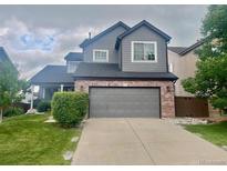 Charming two-story home featuring a well-manicured lawn and two-car garage at 9758 Red Oakes Dr, Highlands Ranch, CO 80126