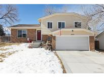 Two-story home boasts a brick facade, well-maintained lawn, and attached two-car garage at 4879 S Xenophon St, Morrison, CO 80465