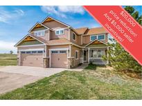 Inviting two-story home featuring a welcoming front porch, a well-maintained lawn, and a spacious two-car garage at 40900 Red Fox Cir, Elizabeth, CO 80107