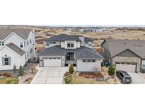 An attractive two-story home with a neutral color palette, large garage, and meticulously kept landscaping at 7077 Copper Sky Cir, Castle Pines, CO 80108