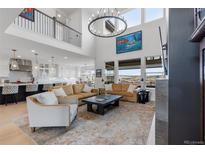 Bright living room features high ceilings, an open floor plan, and large windows with scenic views at 7077 Copper Sky Cir, Castle Pines, CO 80108
