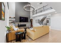 Bright living room boasts fireplace, hardwood floors, and elegant chandelier at 7077 Copper Sky Cir, Castle Pines, CO 80108