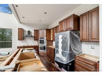 Unfinished kitchen featuring new cabinetry, stainless steel appliances, and dark hardwood floors at 1810 Saddleback Dr, Evergreen, CO 80439
