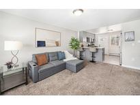 Inviting living room featuring plush carpet, a comfortable sofa, and an open flow to the kitchen and breakfast bar at 4810 W 8Th Ave, Denver, CO 80204