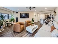 Bright living room boasts stylish seating, a ceiling fan, and hardwood floors at 100 Park W Ave # 605, Denver, CO 80205