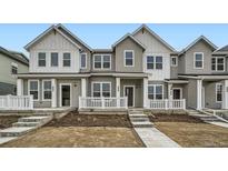A charming two-story townhome with a welcoming front porch and manicured landscaping at 702 N Bently St, Watkins, CO 80137
